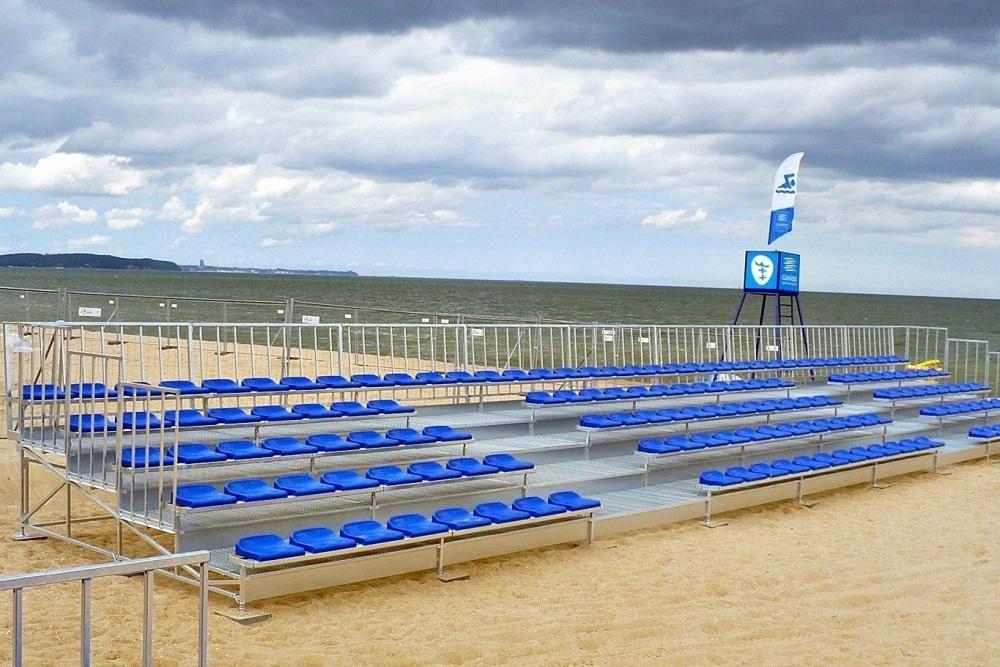 tribúny - päť radov s modrými sedadlami na plážovom - volejbalovom ihrisku